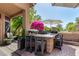 Outdoor kitchen with bar, grill, and shade, ideal for entertaining at 5018 E Kathleen Rd, Scottsdale, AZ 85254