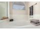 Bathroom featuring a bright white tub, window with blinds, and neutral walls at 556 W Sagebrush St, Gilbert, AZ 85233