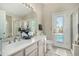 Bathroom featuring double sinks, tile flooring, door to the pool, and neutral countertops at 556 W Sagebrush St, Gilbert, AZ 85233