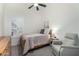 Bedroom with a ceiling fan, shuttered window, and a cozy armchair at 556 W Sagebrush St, Gilbert, AZ 85233