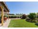 Beautiful backyard with artificial grass, patio, and mature flowering shrubs at 630 E Jensen St # 116, Mesa, AZ 85203