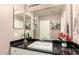 Modern bathroom featuring black tiled countertop, white sink, and decorative cactus at 630 E Jensen St # 116, Mesa, AZ 85203