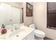 Cozy half bath with a sink, toilet, large mirror, and a decorative painting at 630 E Jensen St # 116, Mesa, AZ 85203