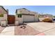 View of the home's driveway and the attached two-car garage with a decorative wooden gate at 630 E Jensen St # 116, Mesa, AZ 85203