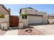 Home features a driveway leading to an attached two-car garage, complemented by landscaping and a wooden gate at 630 E Jensen St # 116, Mesa, AZ 85203