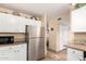 Bright kitchen with stainless steel refrigerator, tiled floors, and white cabinets for storage at 630 E Jensen St # 116, Mesa, AZ 85203