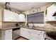 Well-lit kitchen features granite counters, stainless appliances, and stylish white cabinets at 630 E Jensen St # 116, Mesa, AZ 85203