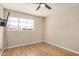 Bright bedroom featuring laminate flooring, a ceiling fan, and a large window at 6312 N 41St Ave, Phoenix, AZ 85019
