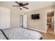 Bedroom featuring wood floors, a ceiling fan, closet doors and a television mounted on the wall at 6312 N 41St Ave, Phoenix, AZ 85019