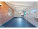 Large bonus room with exposed brick, white ceiling, storage cabinets, and blue painted floors at 6312 N 41St Ave, Phoenix, AZ 85019