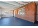 Large bonus room featuring exposed brick walls, white walls, shelving, and blue floors at 6312 N 41St Ave, Phoenix, AZ 85019