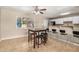 Bright dining area featuring tile floors, a ceiling fan, and a bar overlooking the modern kitchen, perfect for gatherings at 6312 N 41St Ave, Phoenix, AZ 85019
