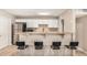 A well-lit kitchen features stainless steel appliances, white cabinetry, and a breakfast bar with seating for four at 6312 N 41St Ave, Phoenix, AZ 85019