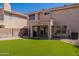 Backyard featuring desert landscaping, an artificial lawn, and a covered patio at 6462 E Raftriver St, Mesa, AZ 85215