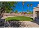 Lush backyard with artificial turf, desert landscaping, and a rock feature at 6462 E Raftriver St, Mesa, AZ 85215