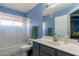 Bright bathroom featuring a tub-shower with modern fixtures and blue painted walls at 6462 E Raftriver St, Mesa, AZ 85215