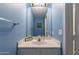 Cozy half bathroom with a mirror and sink, perfect for guests in a calming blue palette at 6462 E Raftriver St, Mesa, AZ 85215