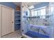 Walk-in shower boasts marble tiles, a blue mosaic bench, rainfall shower head, and a glass door at 6462 E Raftriver St, Mesa, AZ 85215