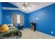 Bright bedroom with blue walls, carpet flooring, and natural light through window at 6462 E Raftriver St, Mesa, AZ 85215