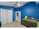 Bright bedroom with blue walls, carpet flooring, and a full sized bed at 6462 E Raftriver St, Mesa, AZ 85215
