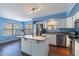 Bright kitchen features white cabinetry, granite counters, stainless appliances, and large center island at 6462 E Raftriver St, Mesa, AZ 85215