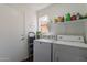 Neat laundry room with a washer, dryer and built-in shelving for storage at 6462 E Raftriver St, Mesa, AZ 85215