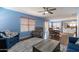 Open living room area features wood flooring and a ceiling fan with easy access to the kitchen and dining area at 6462 E Raftriver St, Mesa, AZ 85215