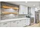 Well-lit kitchen boasts white cabinets, stainless steel appliances, and a gray brick backsplash at 6739 E Thunderbird Rd, Scottsdale, AZ 85254