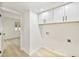 Clean and bright laundry room with white cabinets, modern fixtures, and easy access to other living areas at 6739 E Thunderbird Rd, Scottsdale, AZ 85254