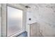 Modern tiled shower features matte black hardware, pebble flooring, and a frosted window at 6739 E Thunderbird Rd, Scottsdale, AZ 85254