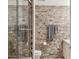 Modern bathroom featuring textured brick walls, glass shower door and stainless steel hardware at 7151 E Rancho Vista Dr # 3001, Scottsdale, AZ 85251