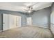 A spacious bedroom features carpet, a ceiling fan, and multiple doors and windows at 7240 N Dreamy Draw Dr # 109, Phoenix, AZ 85020