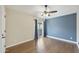 Bedroom with wood floors, blue accent wall, ceiling fan, and sliding glass door at 7240 N Dreamy Draw Dr # 109, Phoenix, AZ 85020