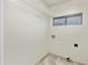 An uncluttered laundry room features tile floors, a wire rack, and a small window at 7240 N Dreamy Draw Dr # 109, Phoenix, AZ 85020