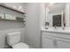 Bright half-bath features floating shelves, toilet, sink and white cabinets at 820 N 8Th Ave # 25, Phoenix, AZ 85007