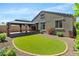 Manicured backyard featuring artificial grass and covered patio at 8872 W Hollywood Ave, Peoria, AZ 85345