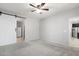 Bedroom featuring neutral carpet, ceiling fan, and a slider barn door to an attached closet at 8872 W Hollywood Ave, Peoria, AZ 85345