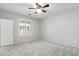 Bedroom features carpet flooring, ceiling fan and shuttered windows with a door to the hallway at 8872 W Hollywood Ave, Peoria, AZ 85345