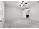 Bedroom with carpet flooring, ceiling fan, and a sliding barn door to the en-suite bathroom at 8872 W Hollywood Ave, Peoria, AZ 85345