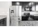 Close-up of stainless steel refrigerator and dark cabinets with granite countertop in the kitchen at 8872 W Hollywood Ave, Peoria, AZ 85345
