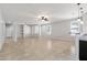 Open-concept living room with tile floors, neutral paint, ceiling fan, and sightlines to kitchen at 8872 W Hollywood Ave, Peoria, AZ 85345