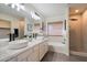 Bright bathroom featuring double sinks, tub, and walk-in shower with modern fixtures at 9143 W Kings Ave, Peoria, AZ 85382