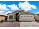 Charming single-story home featuring a three car garage, desert landscaping, and a beautiful entry archway at 9143 W Kings Ave, Peoria, AZ 85382
