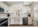 Bright kitchen features white cabinetry, stainless appliances, and a farmhouse sink under a window at 9143 W Kings Ave, Peoria, AZ 85382
