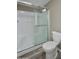 Bathroom featuring a shower-tub combo, a neutral tile surround, and a toilet at 9733 E Baywood Ave, Mesa, AZ 85208