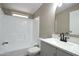Bathroom featuring a shower-tub combo, white cabinets, and white tile, offering a clean look at 9733 E Baywood Ave, Mesa, AZ 85208