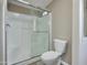 Bathroom featuring a shower-tub combo with sliding doors, a toilet, and neutral finishes at 9733 E Baywood Ave, Mesa, AZ 85208