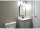 Neutral bathroom with white toilet, gray vanity, and sleek black hardware at 9733 E Baywood Ave, Mesa, AZ 85208