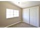 Bright bedroom with tan walls, cozy carpet, a closet, and a window for natural light at 9733 E Baywood Ave, Mesa, AZ 85208