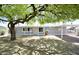 Charming gray house with shade tree, covered carport and desert landscaping at 9733 E Baywood Ave, Mesa, AZ 85208